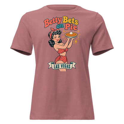Betty Bets on Pie Relaxed T-Shirt in Heather Mauve, front view, Downtown Betty in a polka dot swimsuit holds up a pumpkin pie like a jackpot and winks