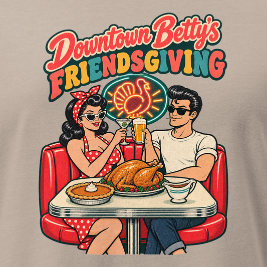 Downtown Betty's Friendsgiving Relaxed T-Shirt in Heather Stone, close-up of the front print, Downtown Betty and Fremont Frank toast over a turkey dinner in a retro diner booth