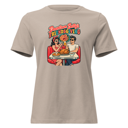 Downtown Betty's Friendsgiving Relaxed T-Shirt in Heather Stone, front view, Downtown Betty and Fremont Frank toast over a turkey dinner in a retro diner booth