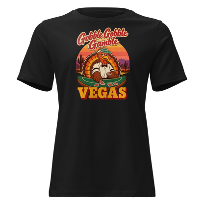 Gobble Gobble Gamble Relaxed T-Shirt in Black, front view, a turkey in a green dealer visor deals blackjack at a felt table under a desert sunset