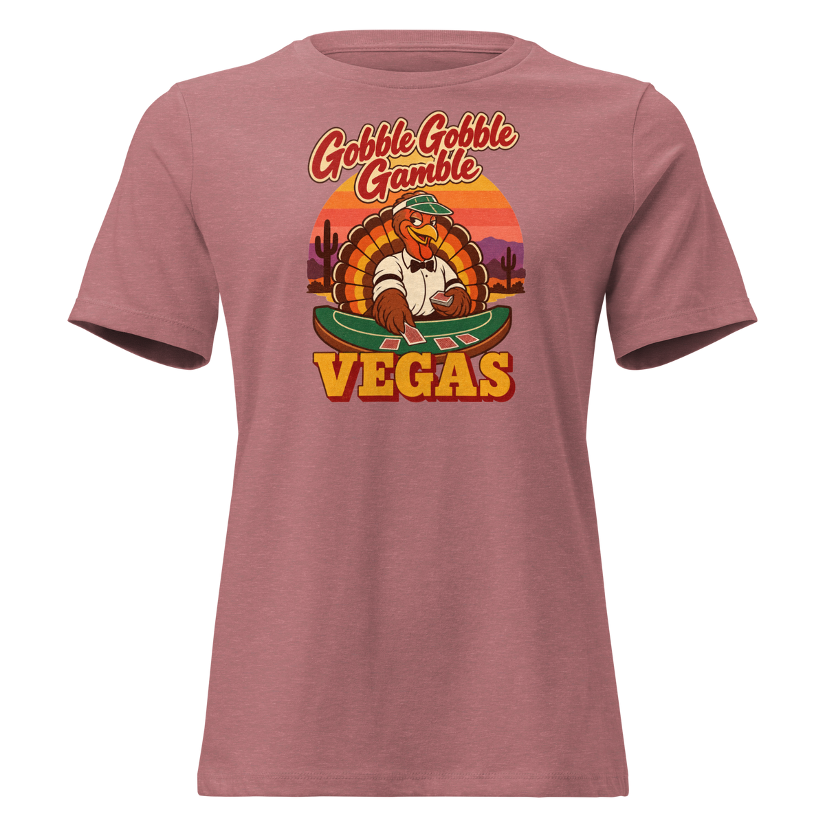 Gobble Gobble Gamble Relaxed T-Shirt in Heather Mauve, front view, a turkey in a green dealer visor deals blackjack at a felt table under a desert sunset