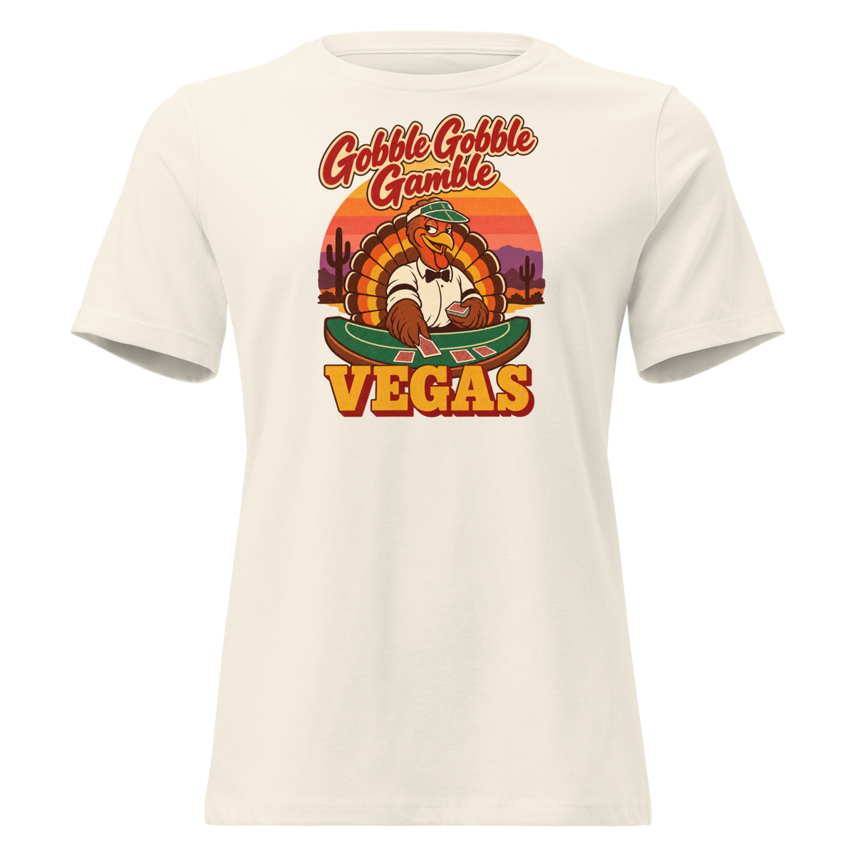 Gobble Gobble Gamble Relaxed T-Shirt in Natural, front view, a turkey in a green dealer visor deals blackjack at a felt table under a desert sunset