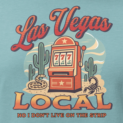 No I Don't Live On The Strip Relaxed T-Shirt in Heather Blue Lagoon, close-up of the front print, retro slot machine on triple 7s among saguaros with a rattlesnake and scorpion