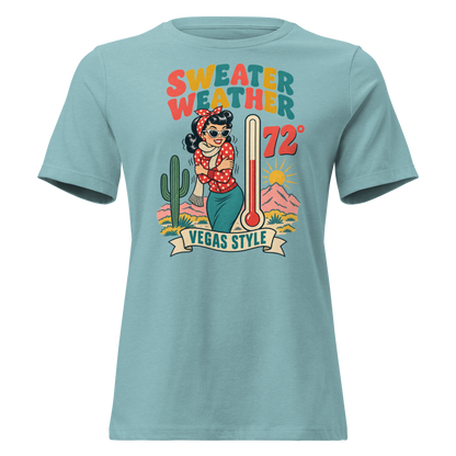 Sweater Weather Relaxed T-Shirt in Heather Blue Lagoon, front view, Downtown Betty shivering in a scarf beside a thermometer reading 72 degrees and a cactus