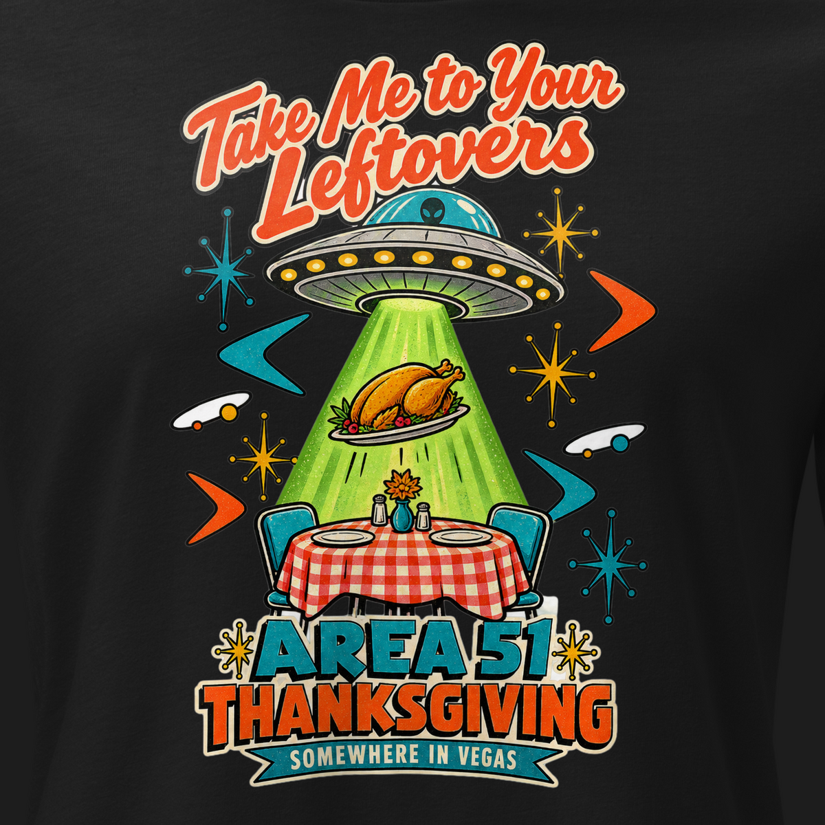 Take Me to Your Leftovers Relaxed T-Shirt in Black, close-up of the front print, a flying saucer beams a roast turkey off a checkered 1950s table among atomic starbursts