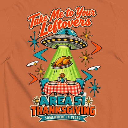 Take Me to Your Leftovers T-Shirt in Yam, close-up of the back print, a flying saucer beams a roast turkey off a checkered 1950s table among atomic starbursts