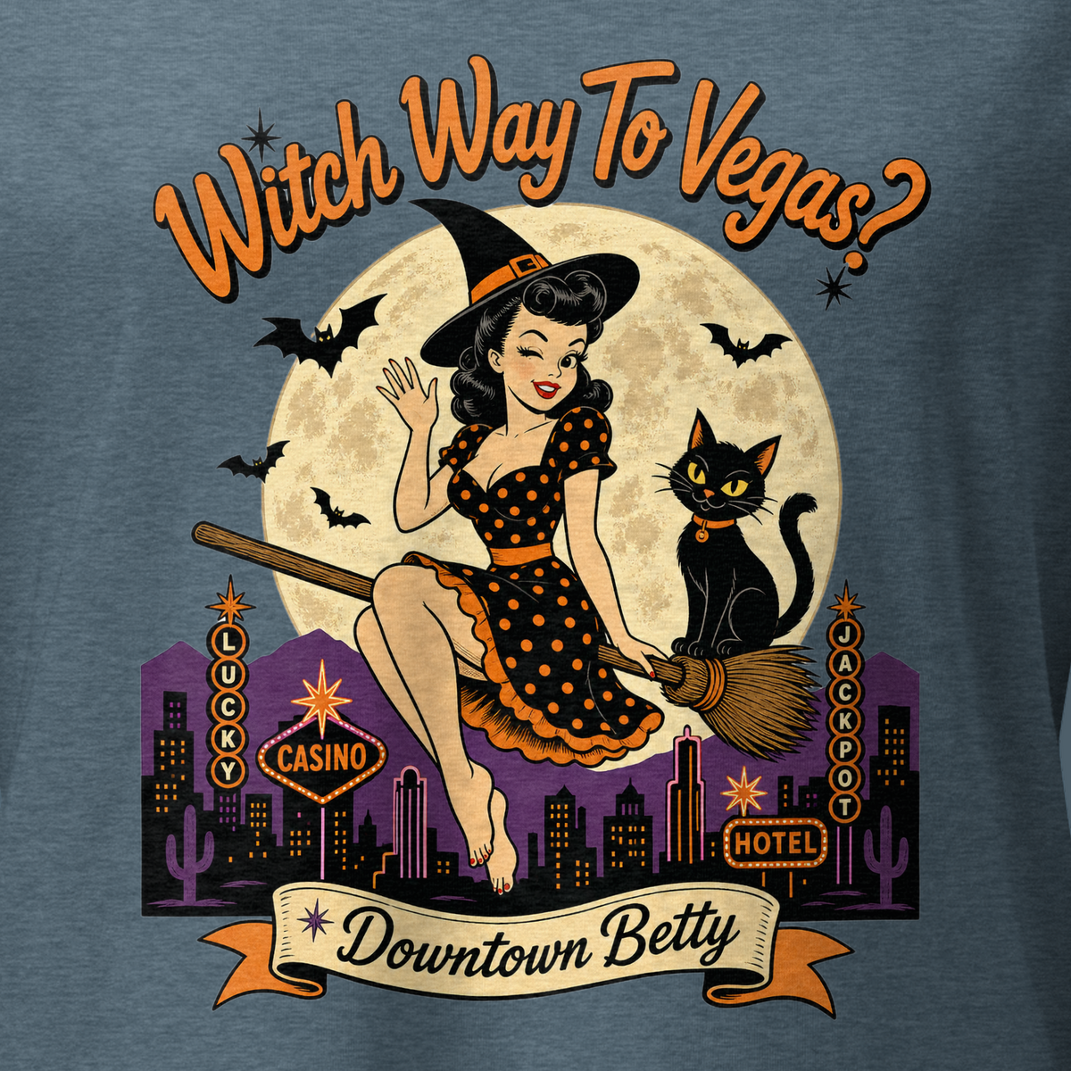 Witch Way To Vegas V-Neck in Heather Slate, close-up of the front print, Downtown Betty pinup witch on a broom over a neon Vegas skyline