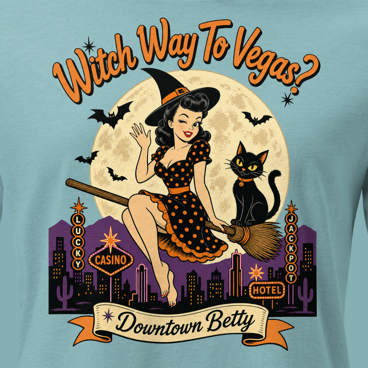 Witch Way To Vegas Relaxed T-Shirt in Heather Blue Lagoon, close-up of the front print, Downtown Betty pinup witch on a broom over neon Vegas
